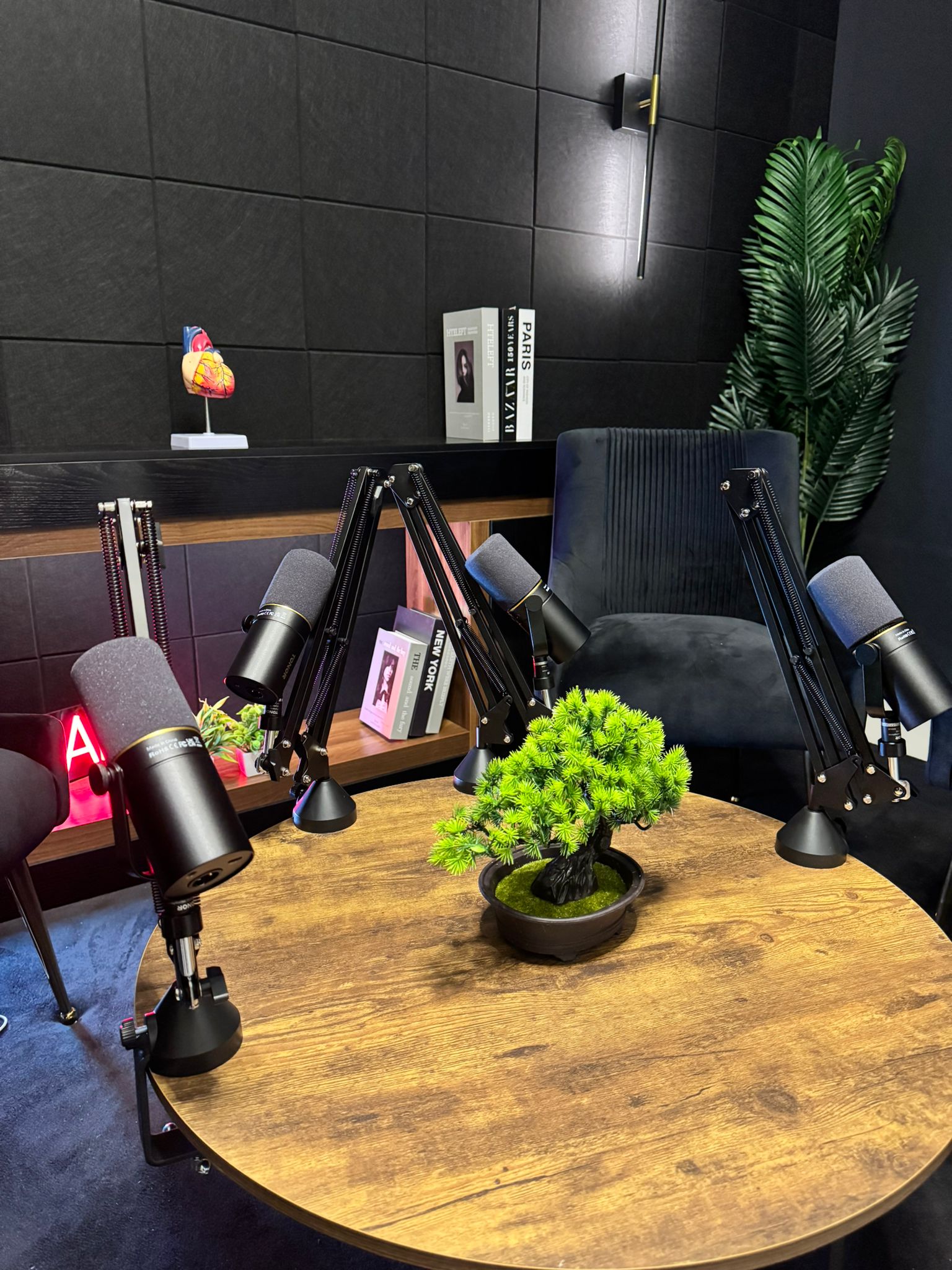 Round table with three podcast mics ready to record in Dubai